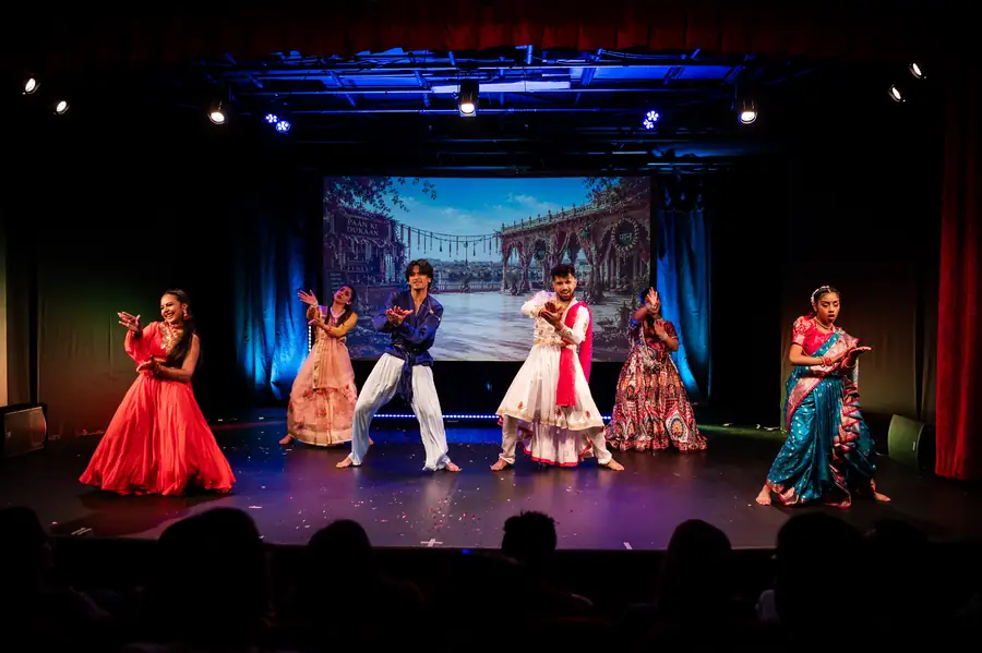 Ensemble in red and white costumes mid-performance